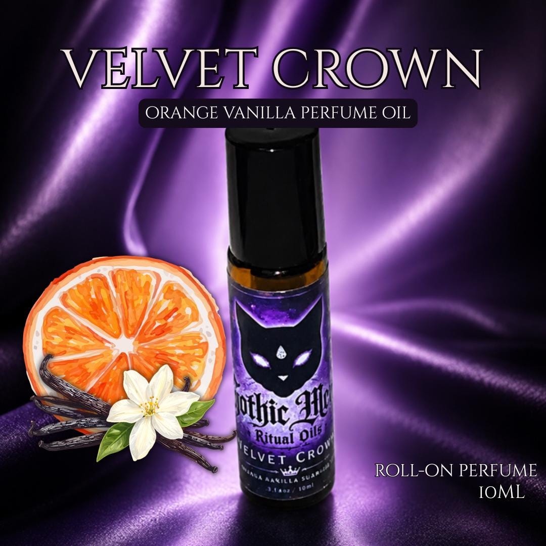Velvet Crown roll-on perfume oil beside an orange slice and a vanilla flower